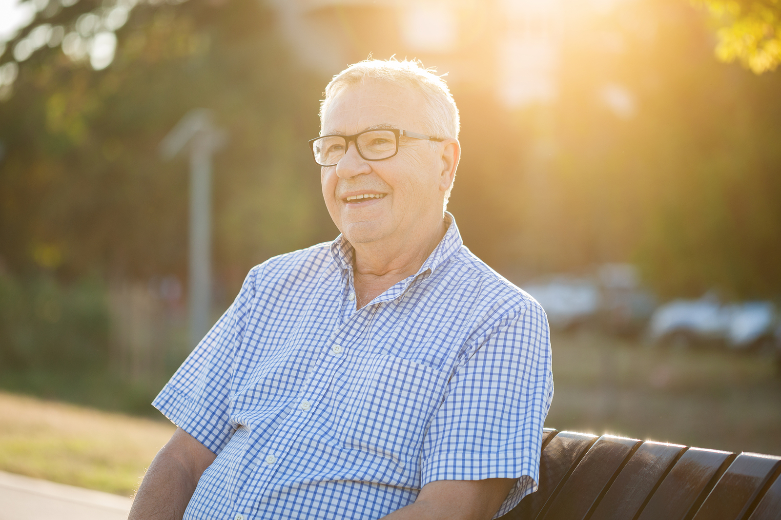 Outdoor portrait of happy senior man who is looking into distance.