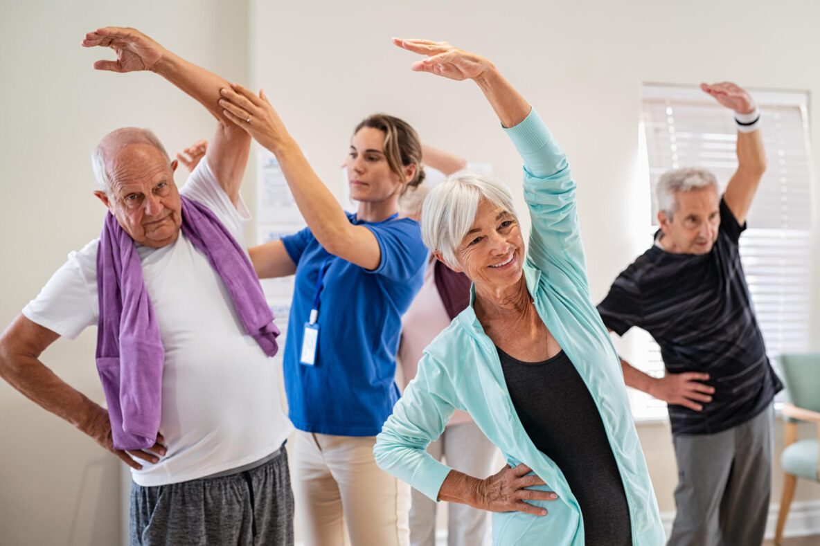 Active,Seniors,Doing,Exercise,With,Physiotherapist,At,Nursing,Home,Gym.