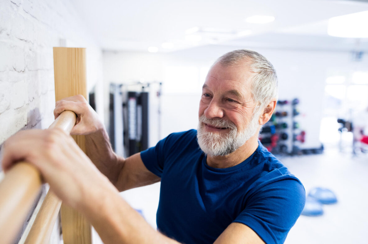 Senior,Man,In,Sports,Clothing,Exercising,On,Wall,Bars