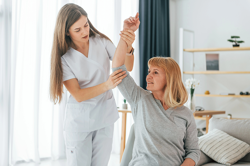 massaging upper body parts senior woman visiting physician