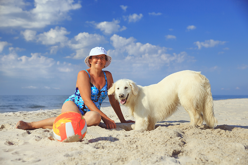 elderly woman with her golder retriever on a sea