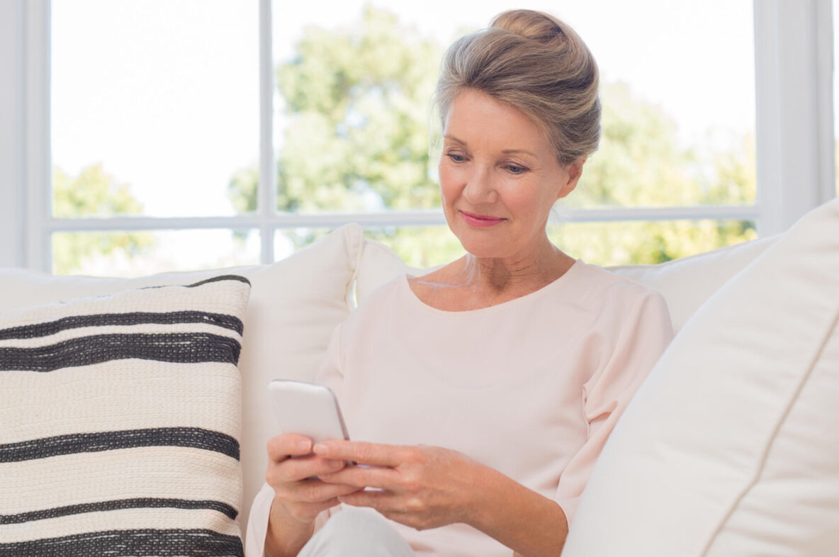 Senior,Woman,Using,Mobile,Phone,While,Sitting,On,Sofa.,Older