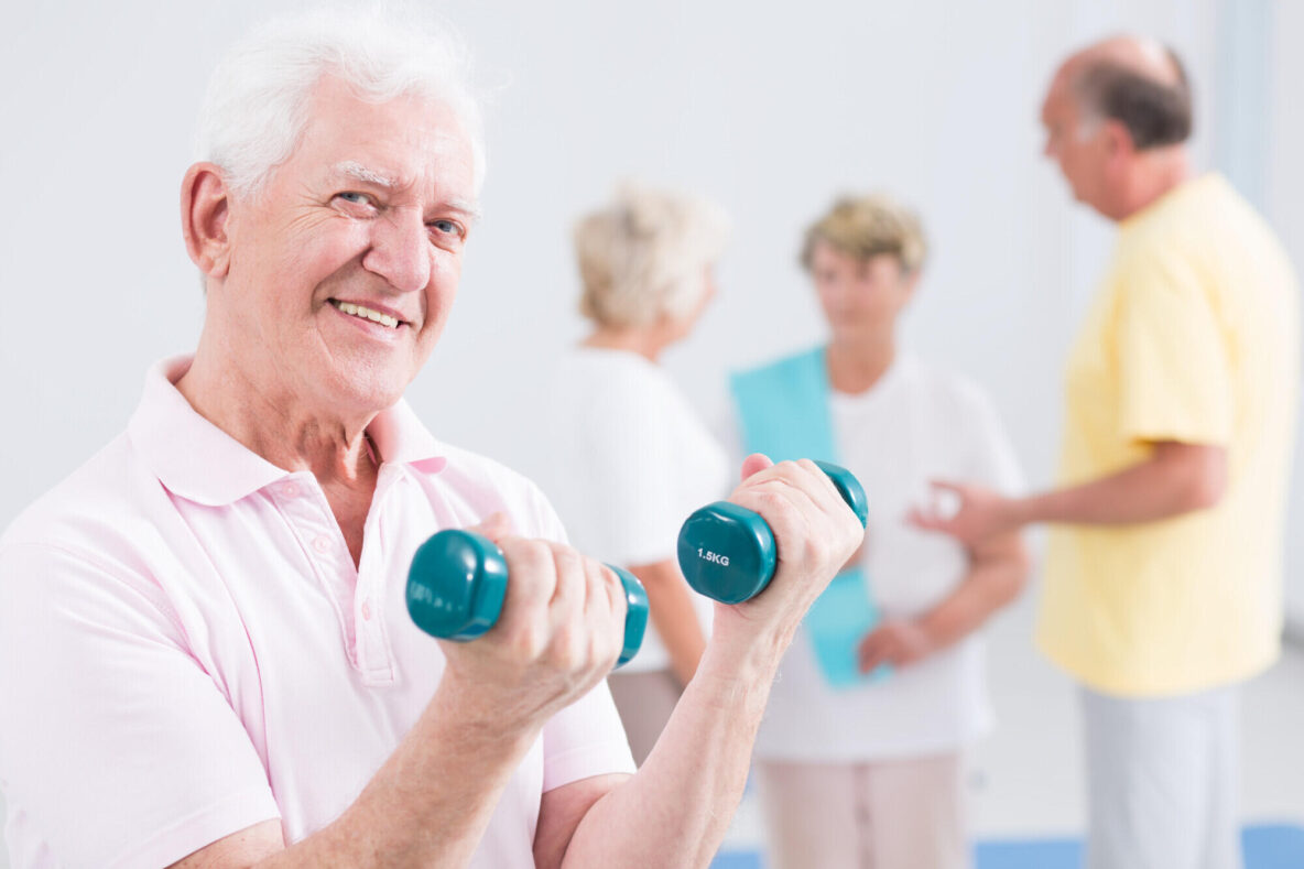 Portrait,Of,An,Optimistic,Elderly,Man,Exercising,With,Weights,In