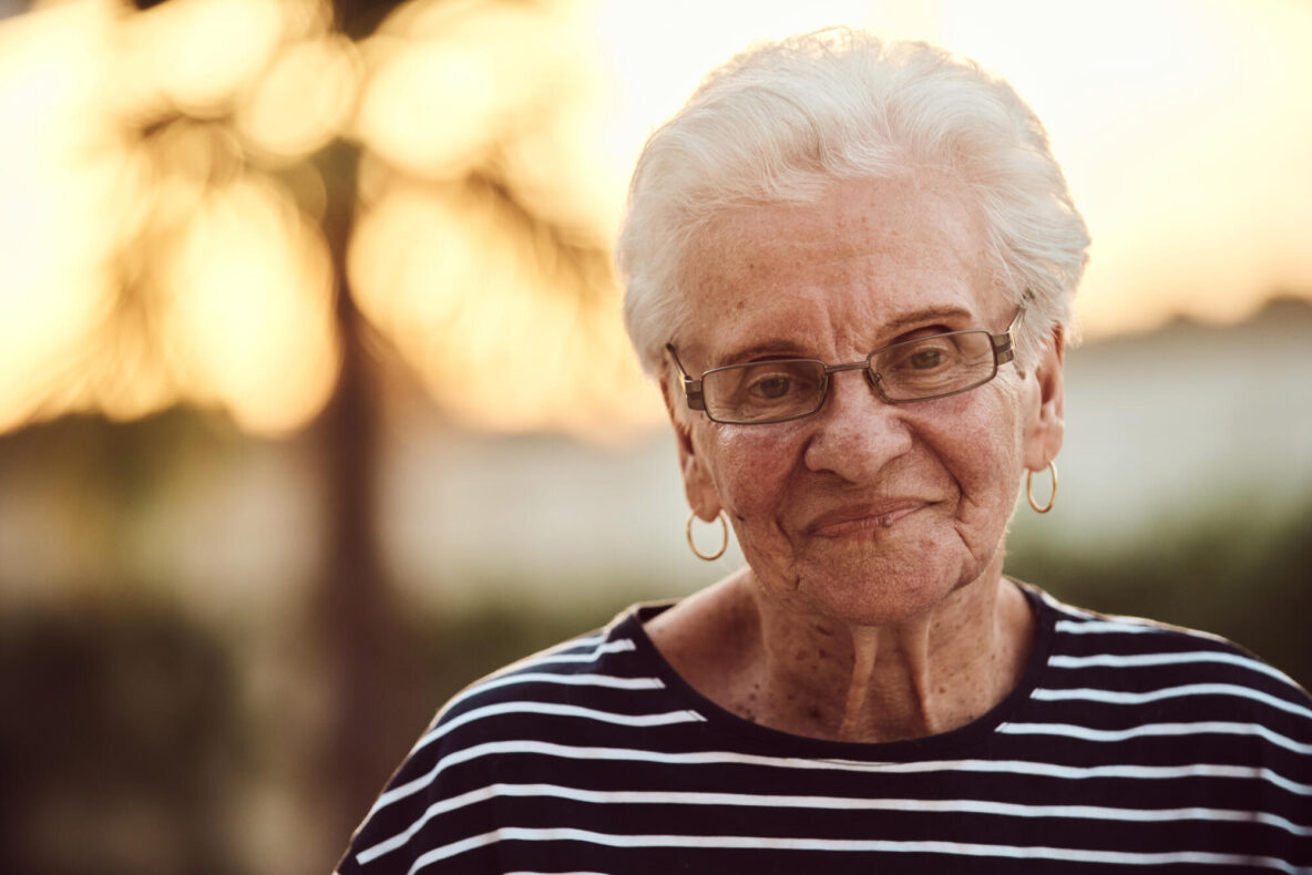 Unfiltered portrait, a real elderly woman sits gracefully in a chair, showcasing the authenticity of aging with wrinkles and a natural face